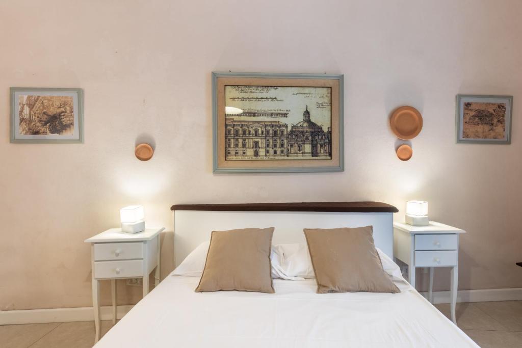 a bedroom with a white bed with two night stands at Dedalo in Noto