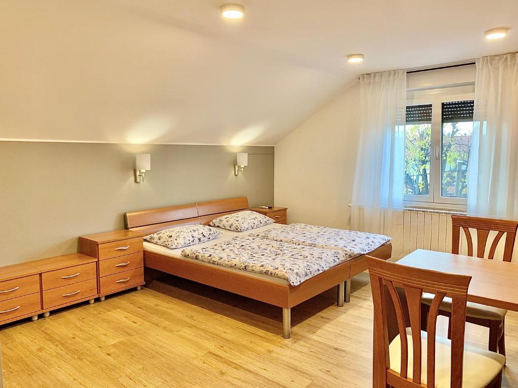 Guest house Stara lipa Tašner - free parking & kitchenette في ماريبور: غرفة نوم بسرير وطاولة طعام