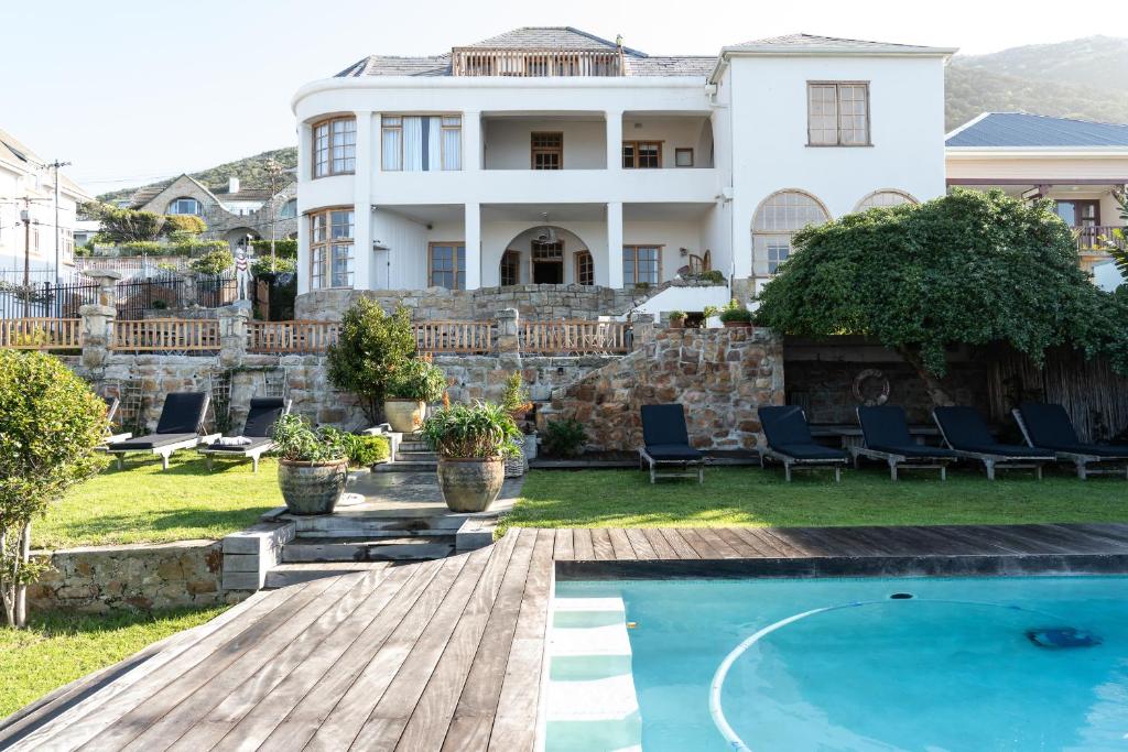 a home with a swimming pool and a house at Chartfield Guesthouse in Kalk Bay