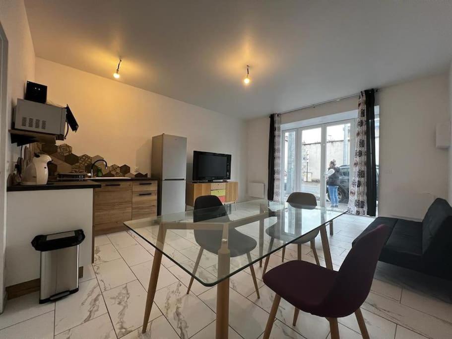 cocina con mesa de cristal y sillas en una habitación en Bel appartement en centre ville de Limoges en Limoges