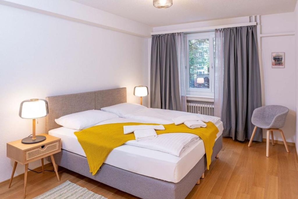 a bedroom with a bed with a yellow blanket on it at one bedroom apartment in trendy Zurich West in Zurich