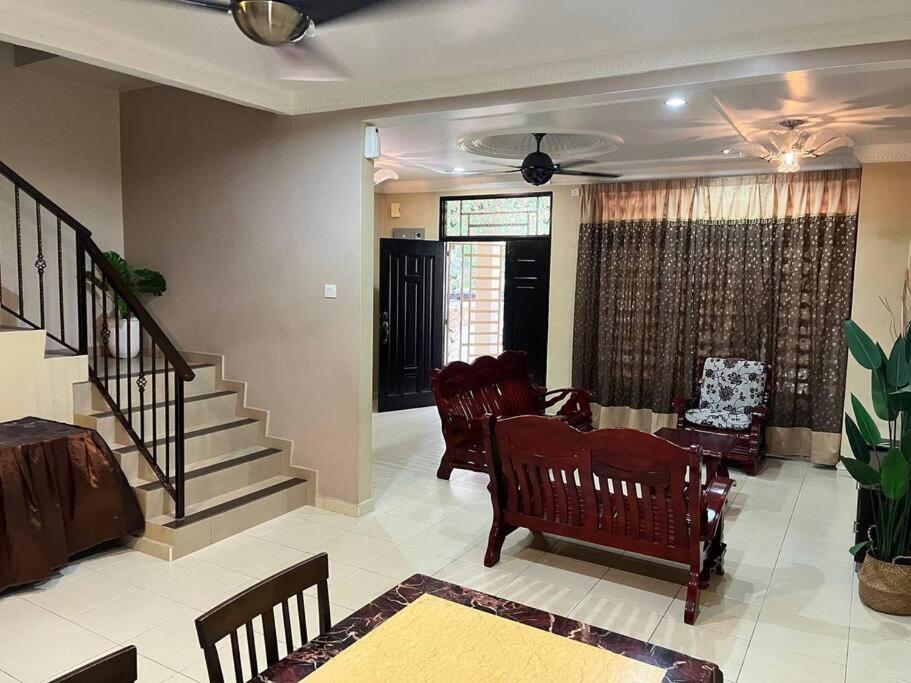 Grand Homestay Kulim 4-Bedroom في Lunas: غرفة معيشة مع كراسي هزاز ودرج