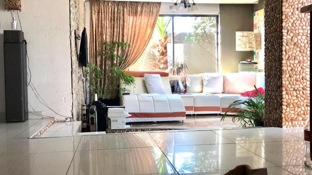 a living room with a white couch in a room at Colourful modern home in Soweto