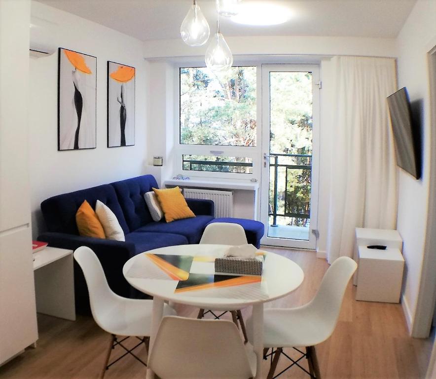 塞羅茨克的住宿－Luksusowy Apartament Nad Zalewem，客厅配有蓝色的沙发和桌子
