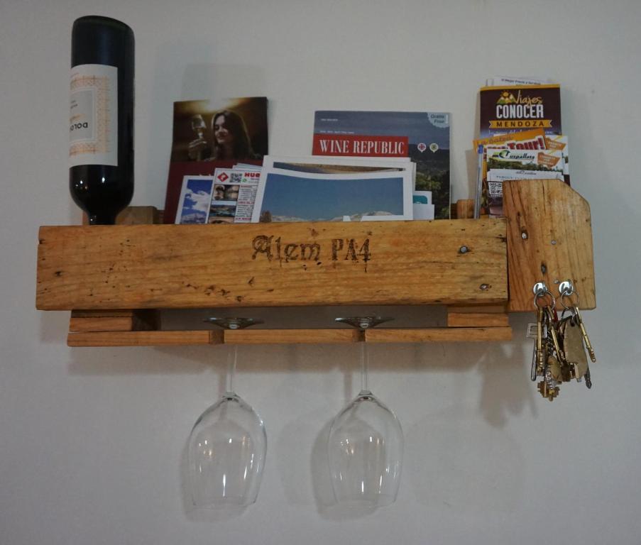 a wooden shelf with wine glasses and books at Alem PA4 Mendoza in Mendoza