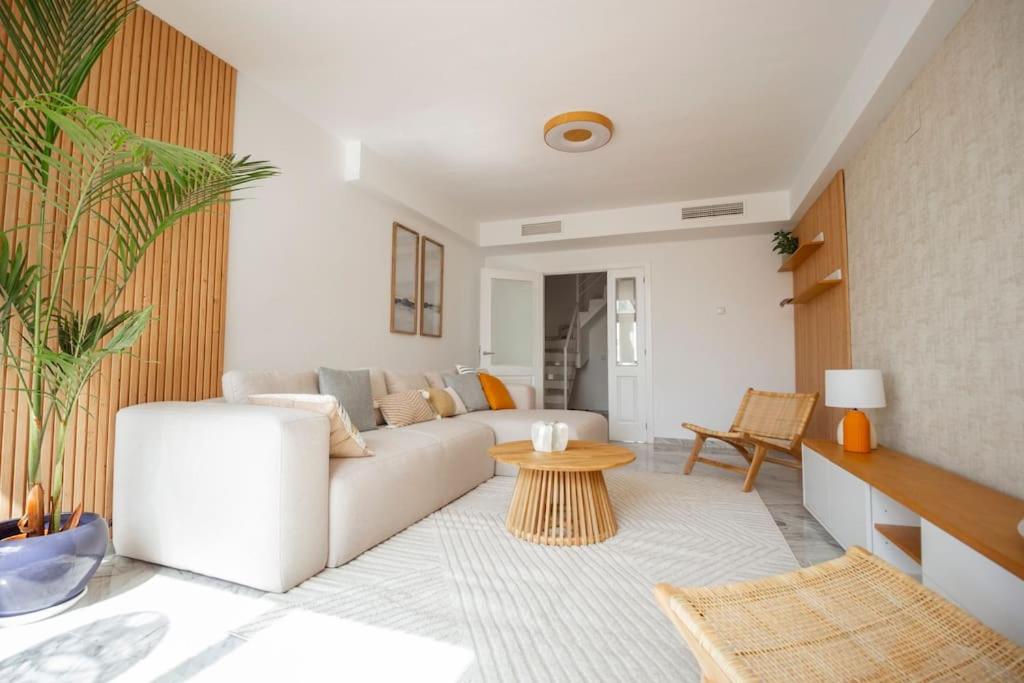 ein Wohnzimmer mit einem weißen Sofa und einem Tisch in der Unterkunft Bright Nordic style penthouse in beachside resort in Marbella