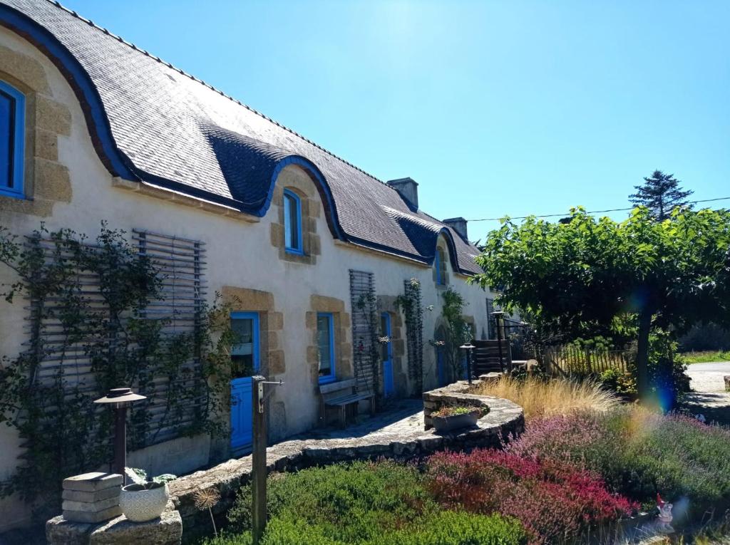 Casa blanca con puertas azules y jardín en Chambres d’hôtes Nordlys, en Pluneret