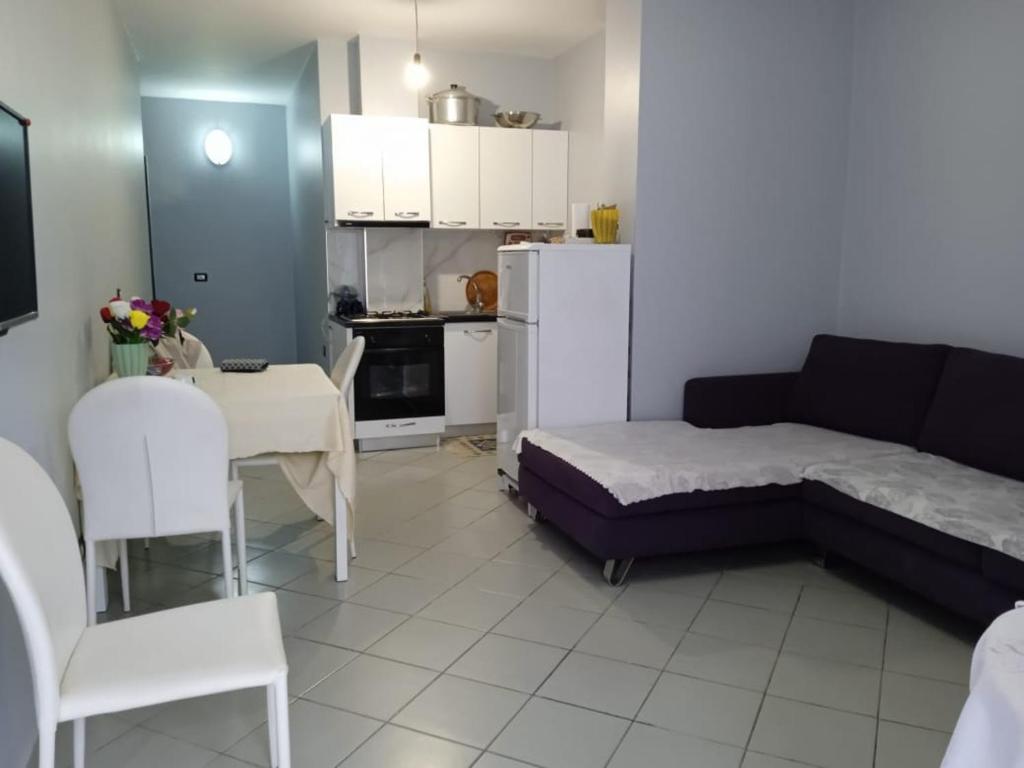 a room with a bed and a table and a kitchen at Apartment Durres in Durrës