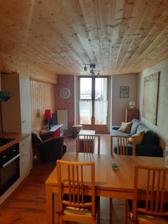 Una cocina y una sala de estar con mesa y sillas. en Le Cocon, en Luchon