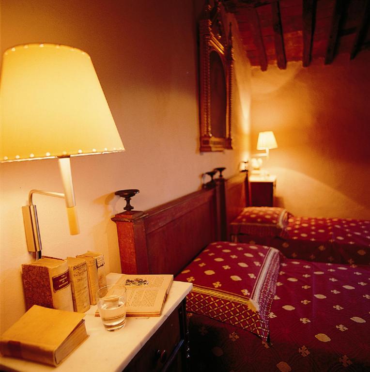 a bedroom with a bed and a table with a lamp at Azienda Agricola Fabbrica Di San Martino in Lucca