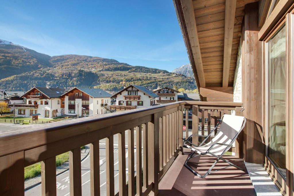 a chair on a balcony with mountains in the background at Olympic Chalet 12 13 in Bormio