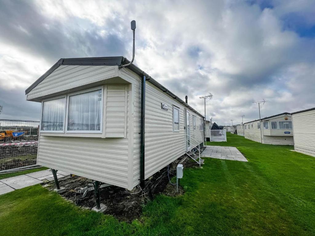 a small house sitting on top of a grass field at Lovely 6 Berth Caravan At Seaview Holiday Park In Kent Ref 47001d in Whitstable