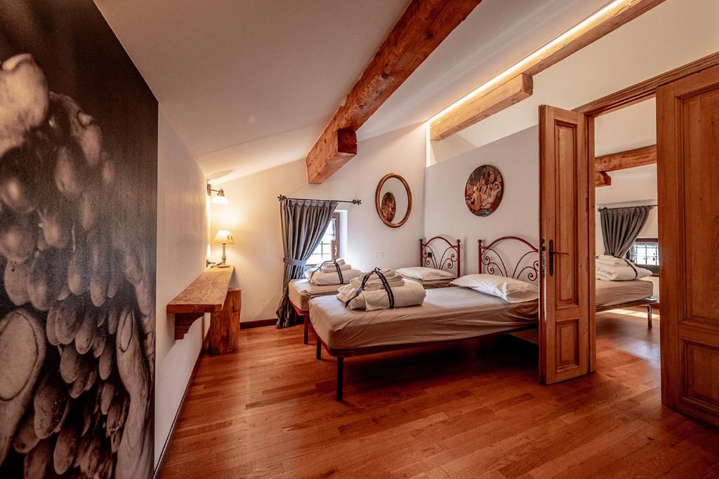 a bedroom with two beds and a mirror at Agriturismo Mas dei Chini in Trento