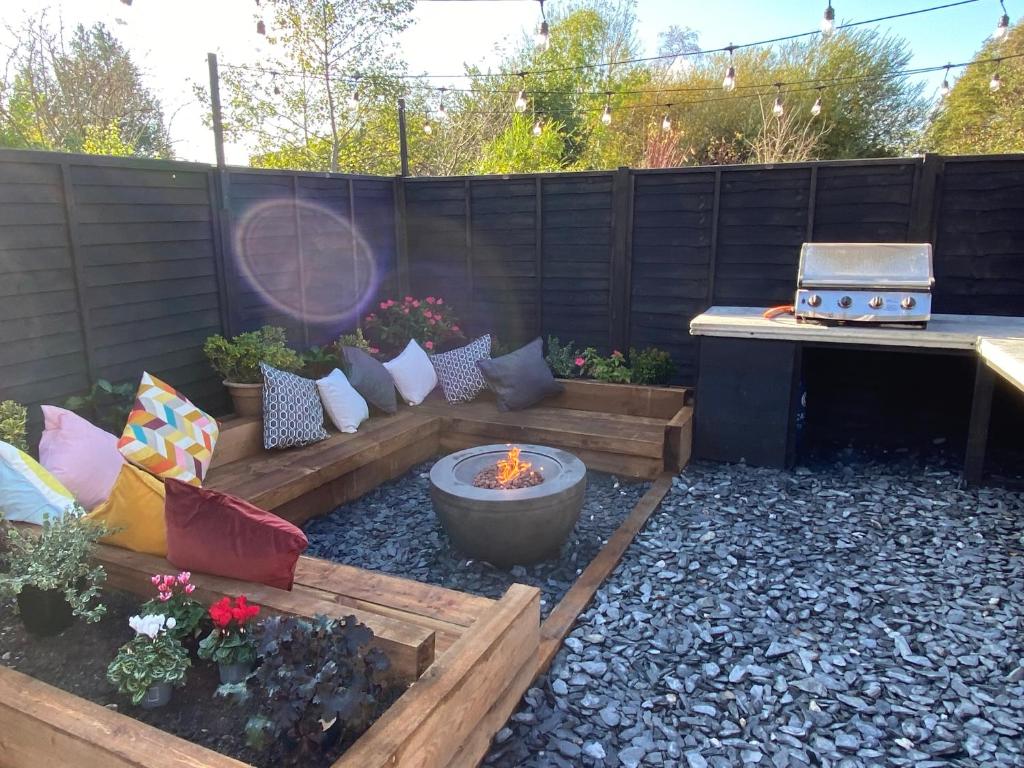 un jardín con una hoguera en el patio trasero en Tipsy Cottage & Games Cabin with fire-pit and BBQ en Ringwood