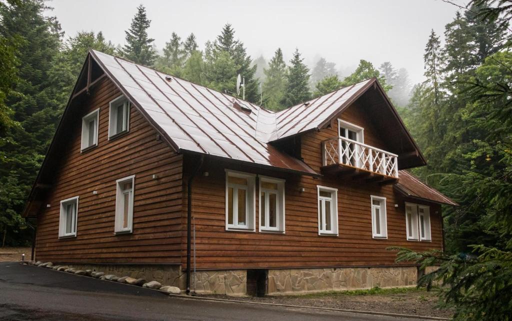 una casa de madera con techo de gambrel en Vila Kotlina - High Tatras 2023, en Vysoké Tatry