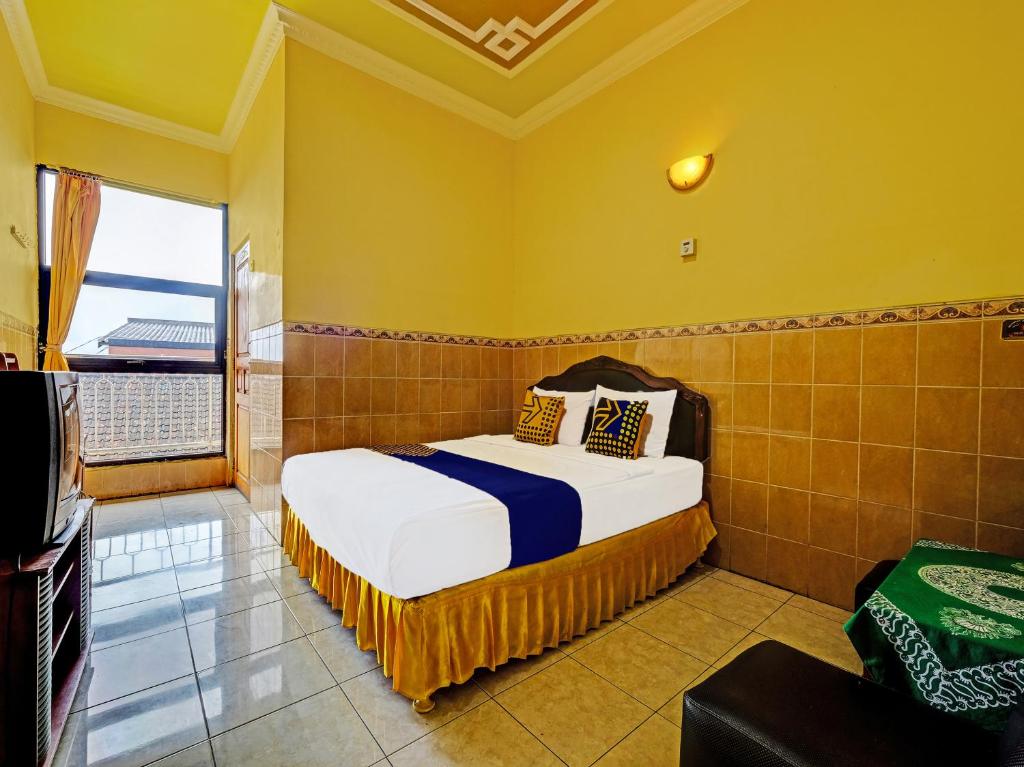a bedroom with a bed and a large window at SPOT ON 91912 Hotel Citra Dewi 2 in Semarang