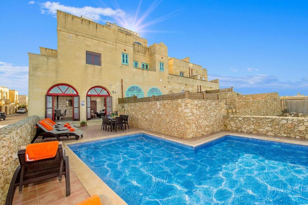 a large swimming pool in front of a building at Ta Kristoff Holiday Home in Qala