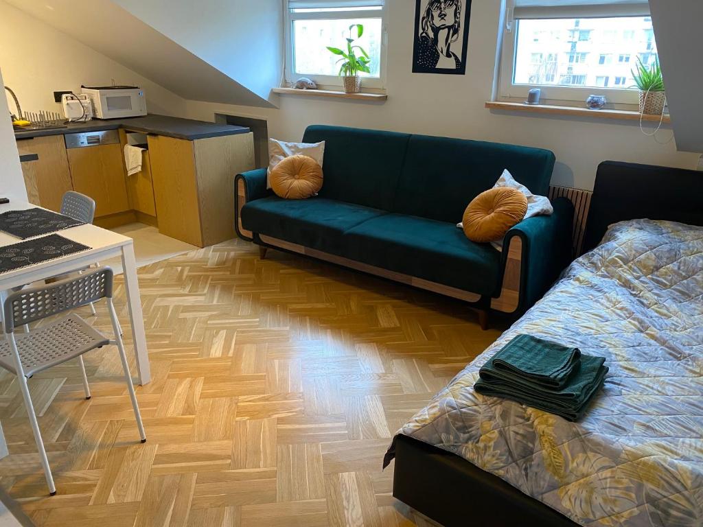 uma sala de estar com um sofá azul e piso em madeira em Kawalerka Premium A 29m2 - po remoncie - nowa! em Varósvia