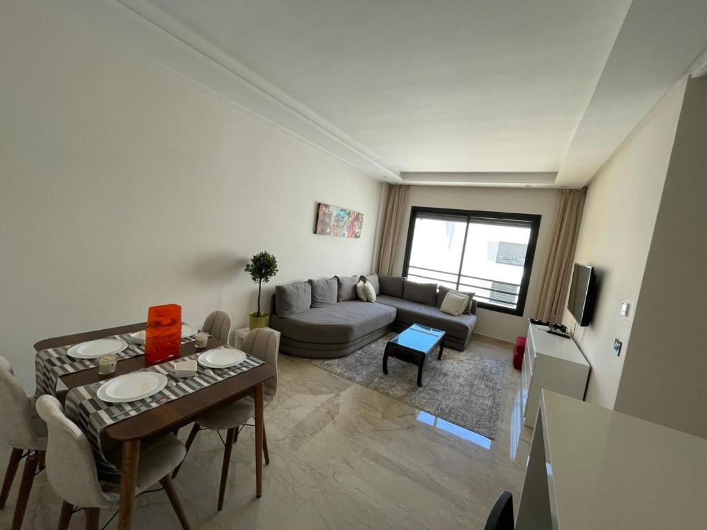 a living room with a table and a couch at SUITE APPARTEMENT BOURGOGNE 2 pièces in Casablanca