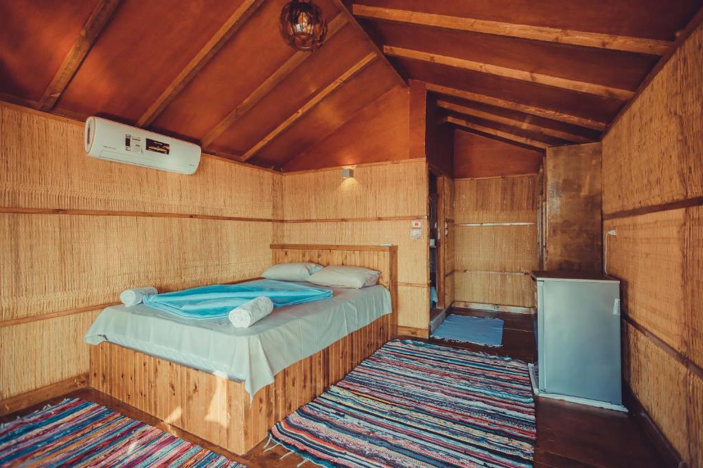 ein Schlafzimmer mit einem Bett in einem Holzzimmer in der Unterkunft Crazy Horse Camp in Nuweiba