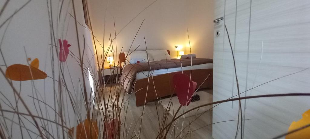 ein Schlafzimmer mit einem Bett in einem Zimmer mit Pflanzen in der Unterkunft La Custarella Di Paestum in Capaccio-Paestum