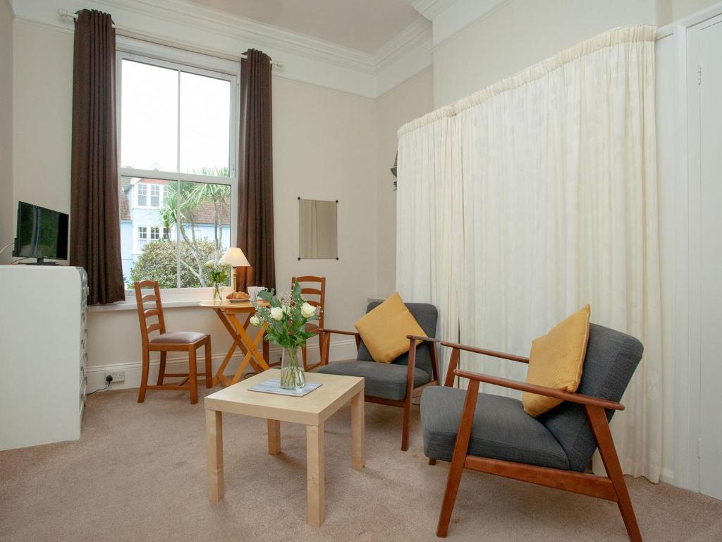 a living room with chairs and a table at Apartment One - Uk39832 in Paignton