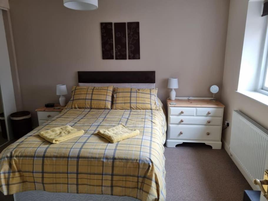 um quarto com uma cama com duas almofadas e uma mesa de cabeceira em The Old Chapel York em York