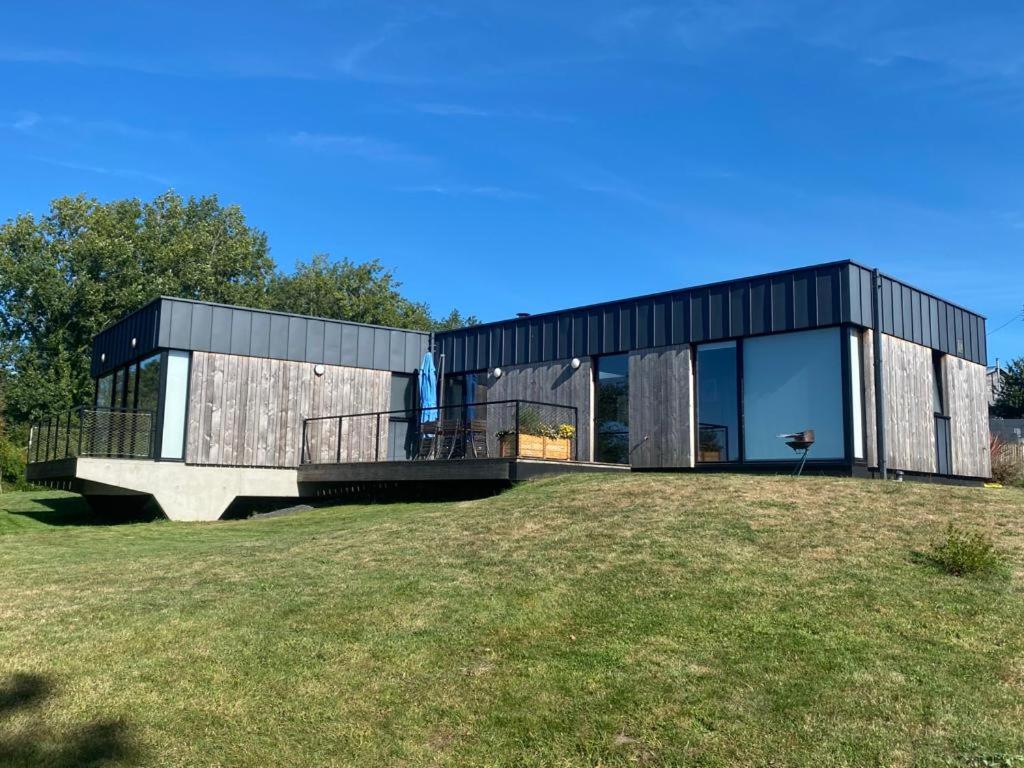 une maison moderne avec un extérieur noir sur une pelouse dans l'établissement Maison de plain-pied avec WIFI, jardin, terrasse à PLEUMEUR - BODOU REF-457, à Pleumeur-Bodou