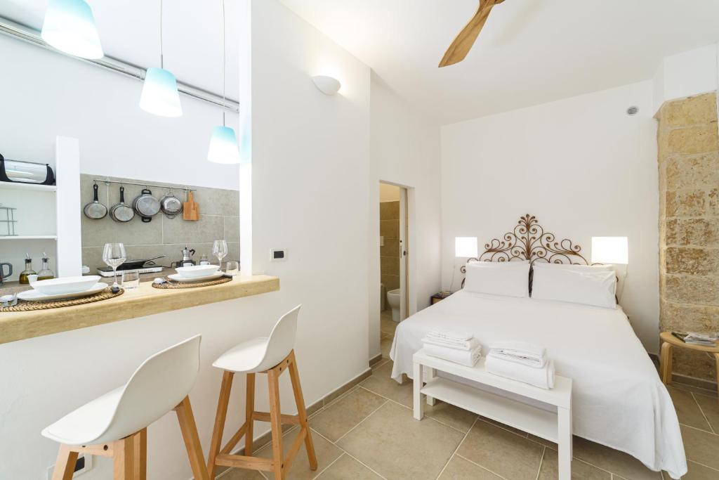 a white bedroom with a white bed and a counter at Apartment Don Giuliano Centro in Lecce