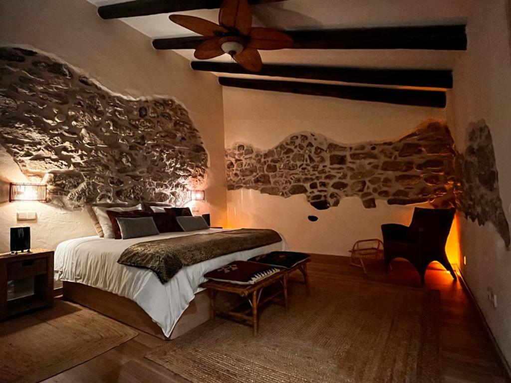 - une chambre avec un lit et un ventilateur de plafond dans l'établissement El Quinto de Luciañez, à Ventas con Peña Aguilera