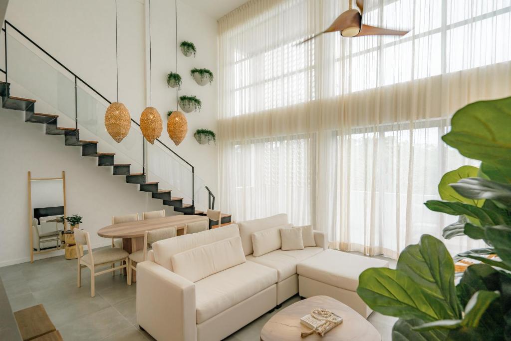 a living room with a white couch and a table at Lumina at Flats Punta Cana Village in Punta Cana