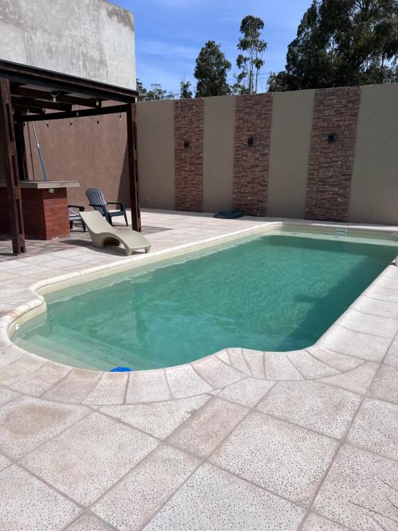 una piscina con una silla junto a un patio en Casa zona parque en Necochea