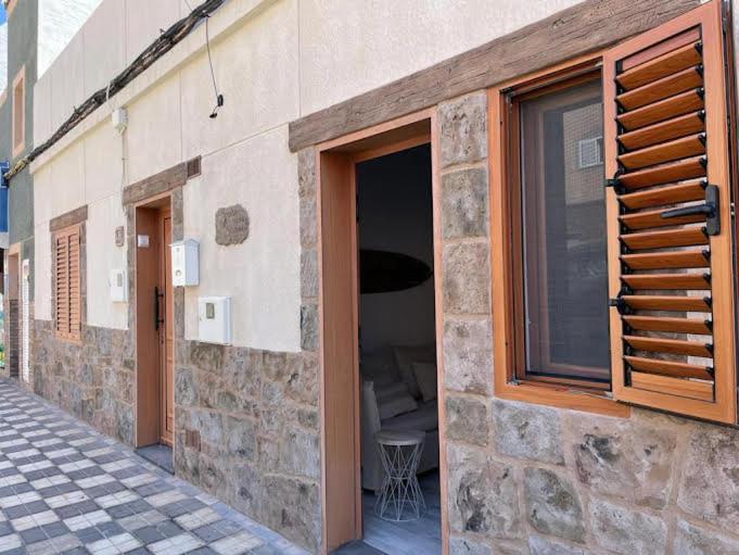 a stone building with a window and a table at CASA MAMA CARINA in Agüimes