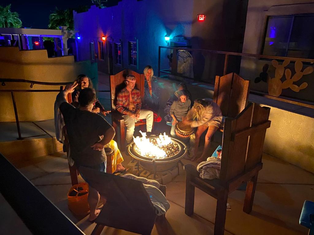 un grupo de personas sentadas alrededor de una hoguera en MI KASA HOT SPRINGS 420,Adults Only, Clothing Optional en Desert Hot Springs