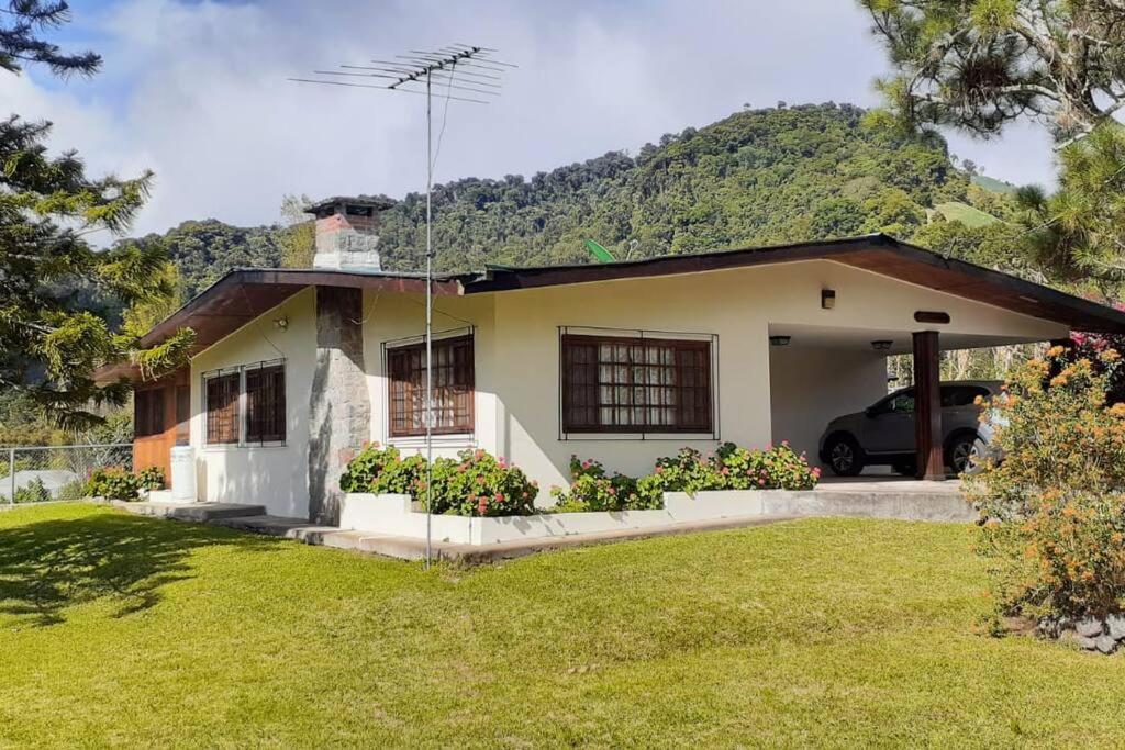 una casa con una montaña en el fondo en Los Alessandria en Cerro Punta