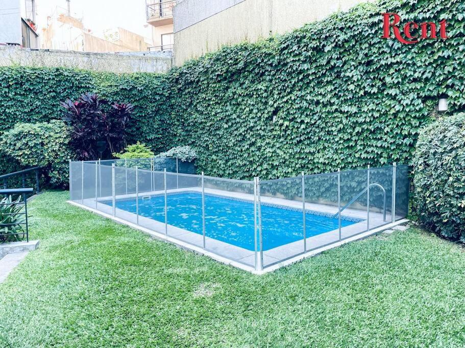 una valla alrededor de una piscina en un jardín en Rent Forest en Buenos Aires