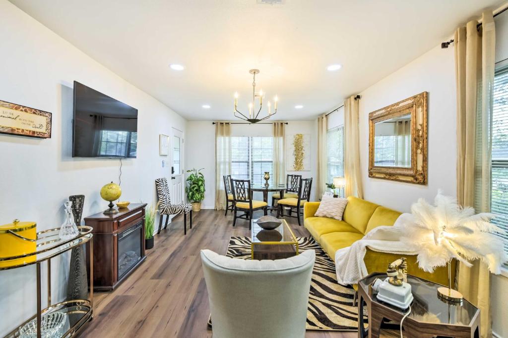 een woonkamer met een gele bank en een tafel bij Lovely Historic Fort Worth Home about 6 Mi to Dtwn! in Fort Worth