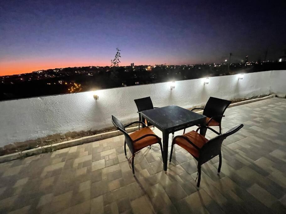 stół i krzesła na dachu w obiekcie Al Mattal w mieście Amman