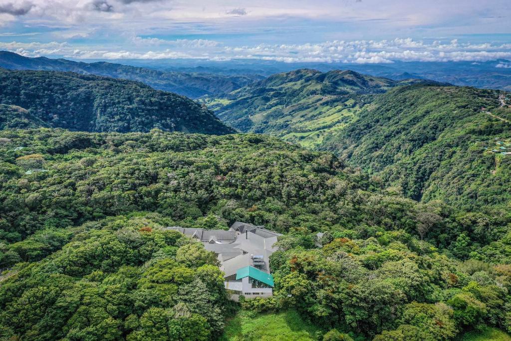 Monteverde Lodge & Gardens by Böëna في مونتيفيردي كوستاريكا: اطلالة جوية على بيت في الجبال