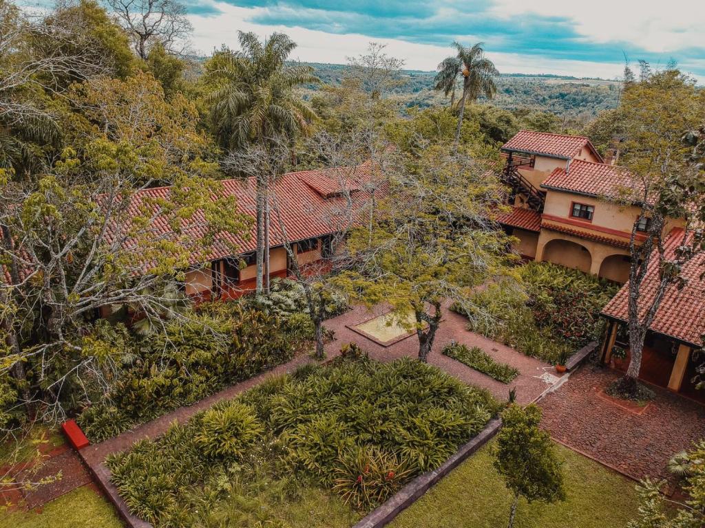 Cette chambre offre une vue sur une maison dotée d'un jardin et d'arbres. dans l'établissement Reserva Natural Iguazú - Posada Puerto Bemberg, à Puerto Libertad
