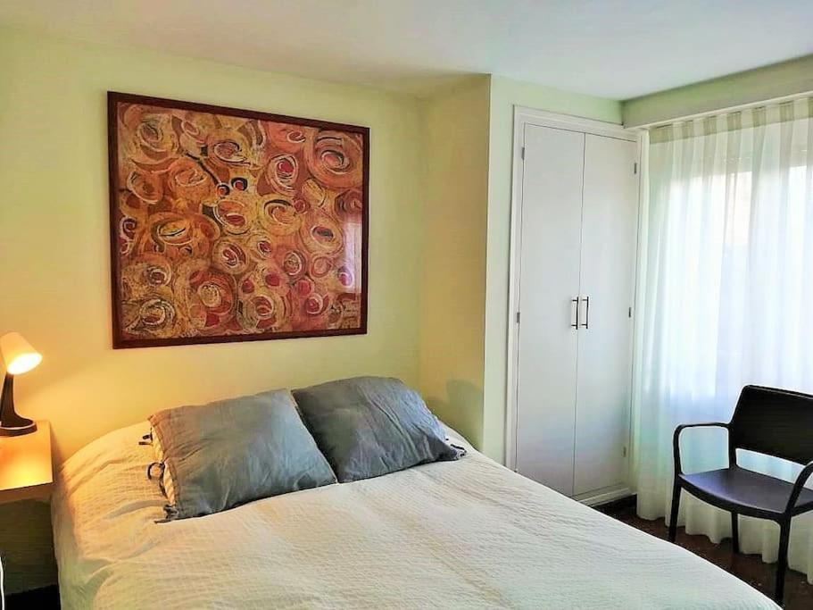 - une chambre avec un lit et une peinture murale dans l'établissement Apartamento Lina, a 20 metros de la playa, à Lloret de Mar