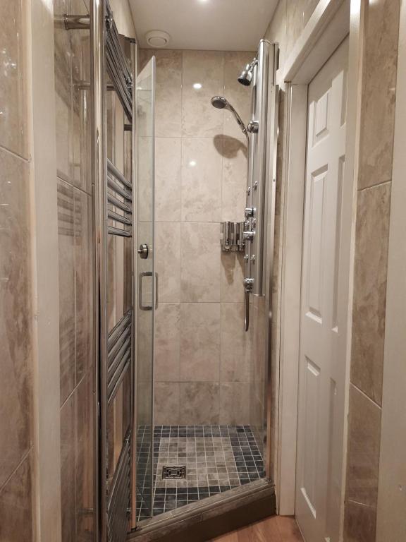 a bathroom with a shower with a glass door at Highlander House B&B in Rothesay