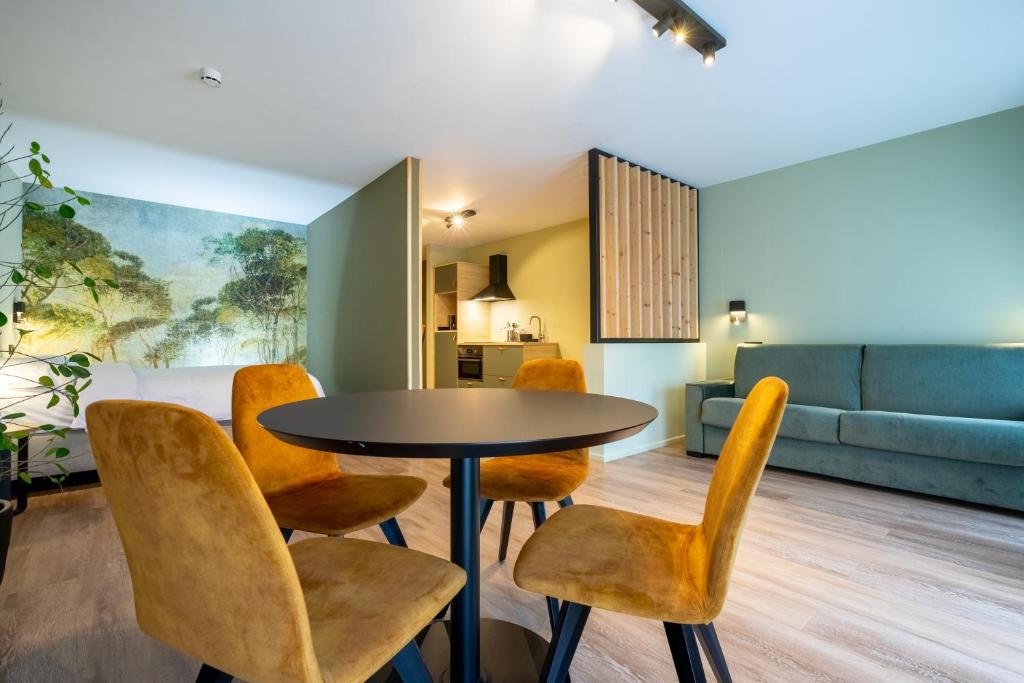 - une salle à manger avec une table et des chaises dans l'établissement Appart hôtel En Ville, à Bastogne