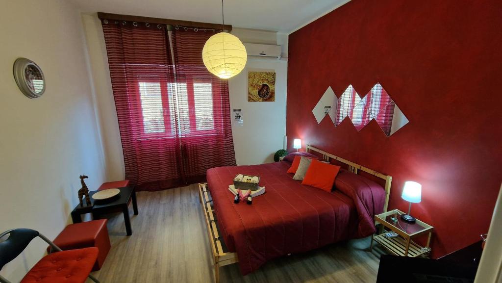 1 dormitorio rojo con 1 cama con pared roja en Testa o Croce Casa Vacanze en Matera