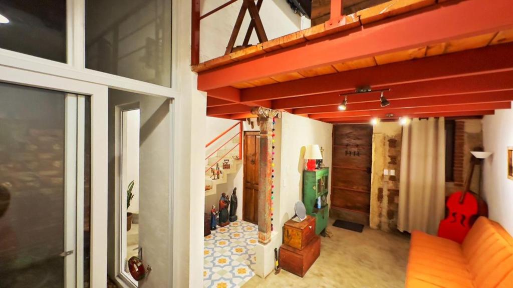a room with a staircase with a guitar on the wall at Cozy Bohemian Loft Apartment close Central Plaza in Antigua Guatemala
