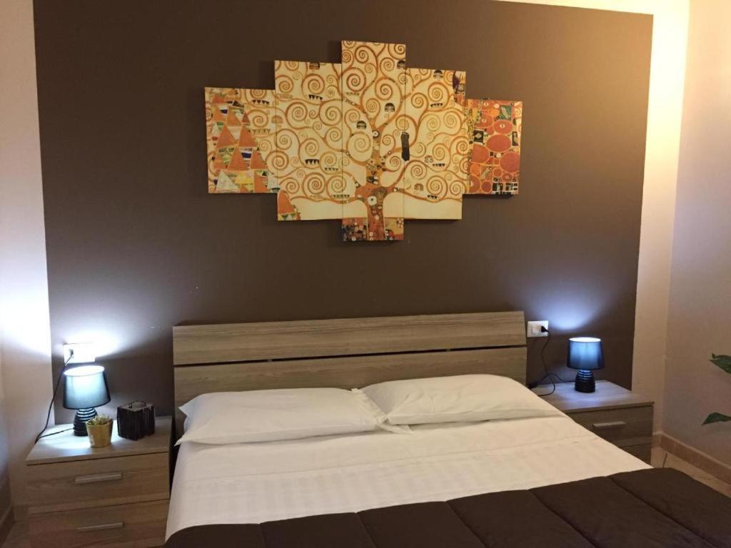 a bedroom with a large bed and a chandelier at HOTEL Via Emilia Ovest 224 SELF CHECK-IN in Parma