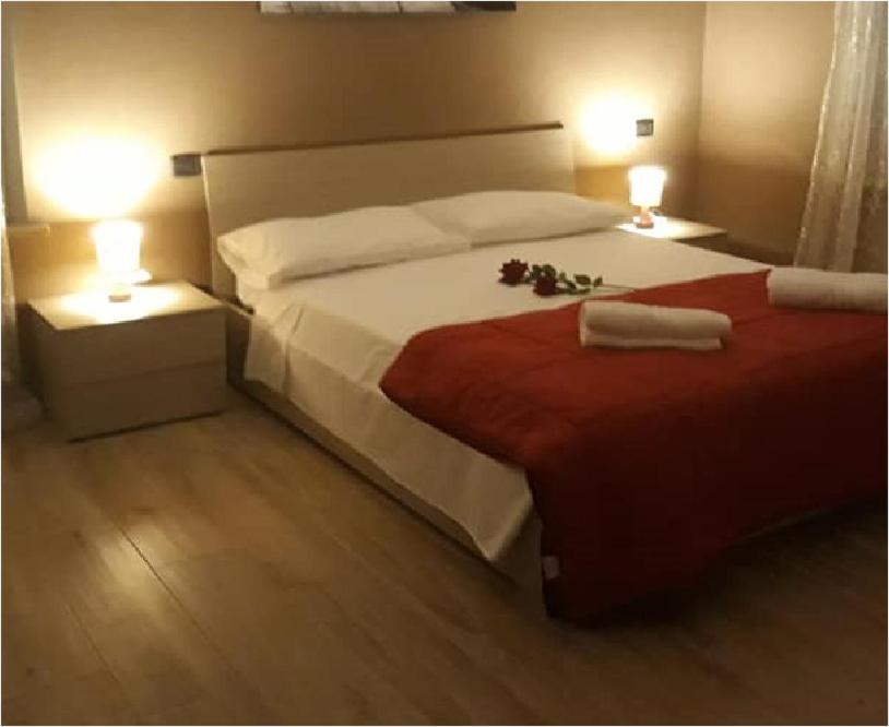 um quarto com uma cama grande e 2 candeeiros em Hotel ELENA 1 SELF CHECK-IN em Parma