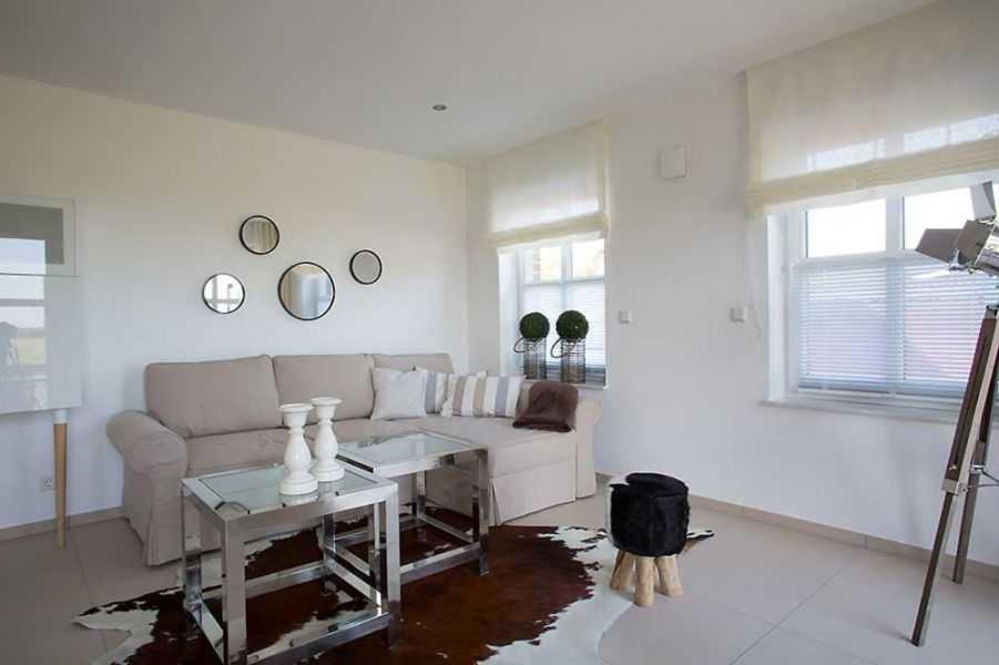 uma sala de estar com um sofá e uma mesa em Schuppen deluxe 01 em Greetsiel