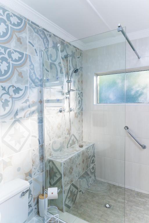 a bathroom with a shower and a sink and a toilet at Gabbys Cottage Guesthouse in Bloemfontein