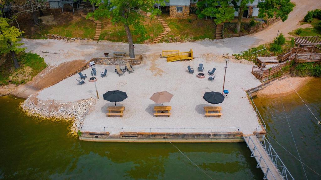 an aerial view of a picnic area with tables and umbrellas at Lakeshore Fishing cabin 1 , dock/boat slip, fire pit. in Lake Ozark